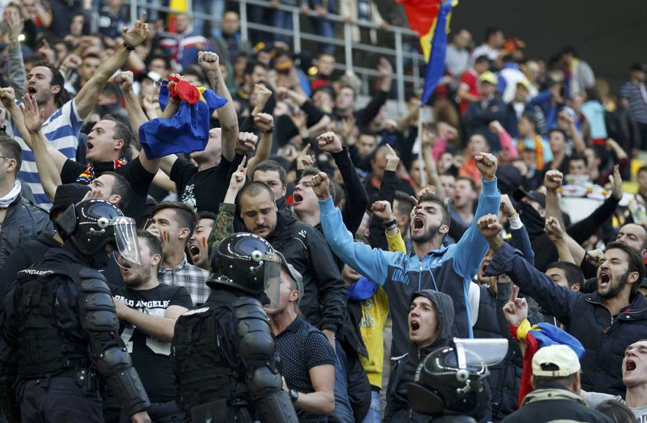 Tifosi rumeni urlano all&#39;indirizzo degli spalti occupati dai supporter ungheresi. In mezzo il cordone della polizia in tenuta antisommossa (Reuters)